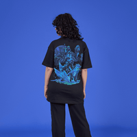 Person wearing a black t-shirt with a colorful graphic design on the back against a blue background