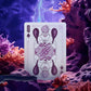 Playing card with a clown design on a surreal underwater background with purple lighting.