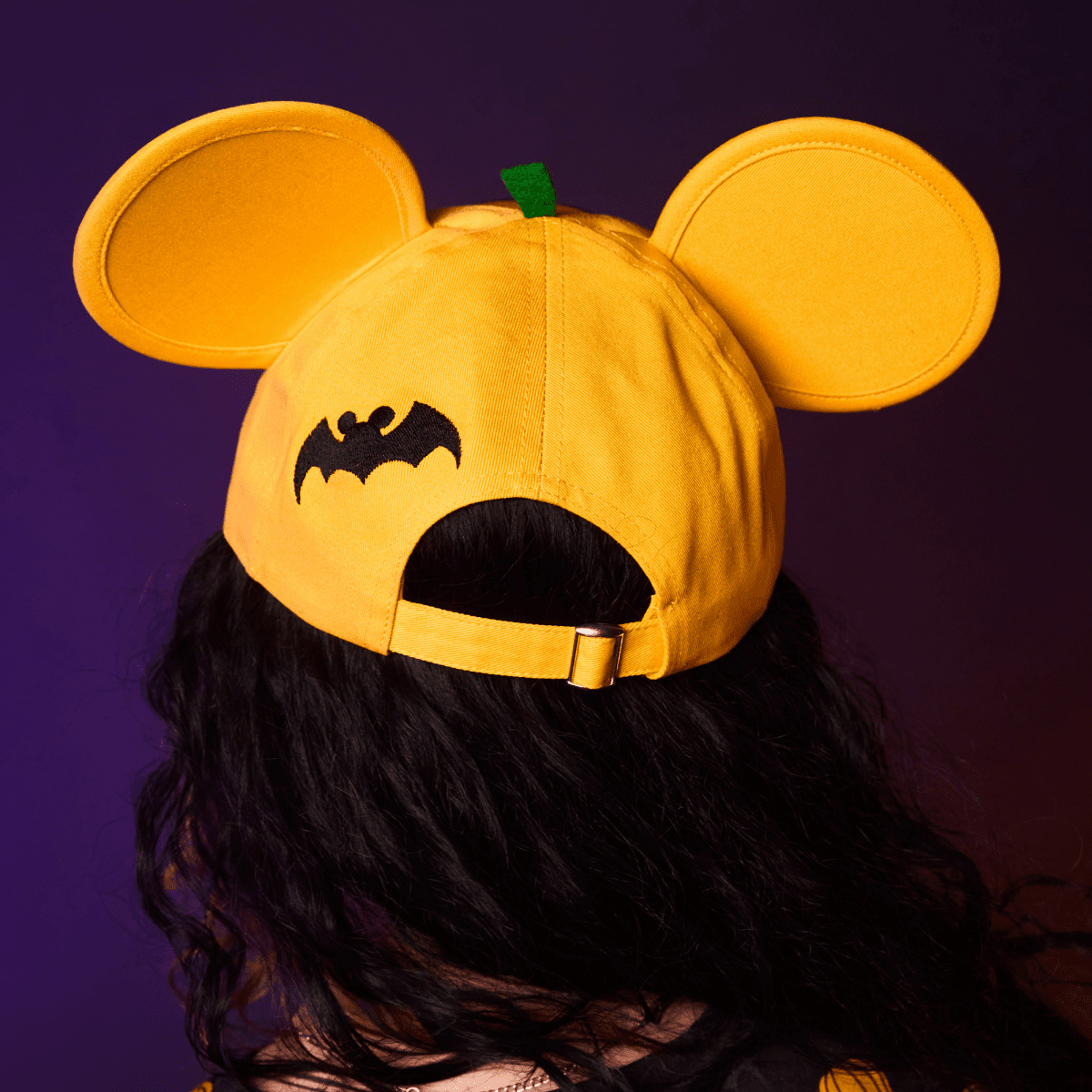 Orange cap with bat design and pumpkin top on a dark background
