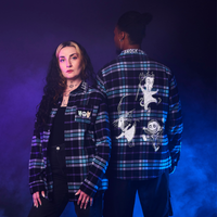 Two people wearing plaid shirts with graphic designs on a gradient purple to blue background