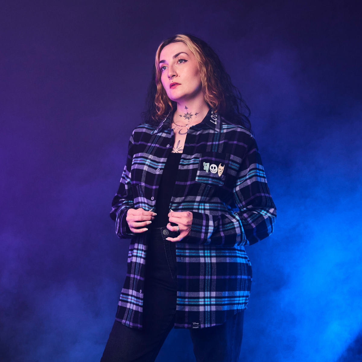 Person wearing a plaid shirt against a blue and purple gradient background