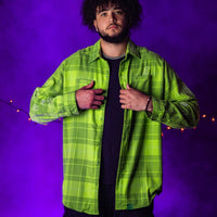 Person wearing a bright green plaid shirt against a purple background