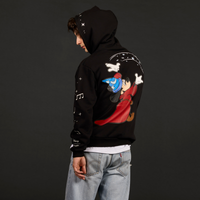 Person wearing a black hoodie with a colorful graphic on the back against a dark background