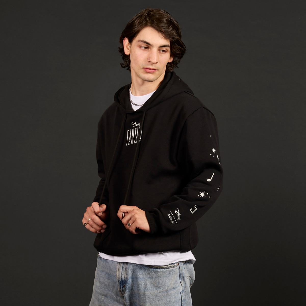Person wearing a black hoodie with white text on a dark background