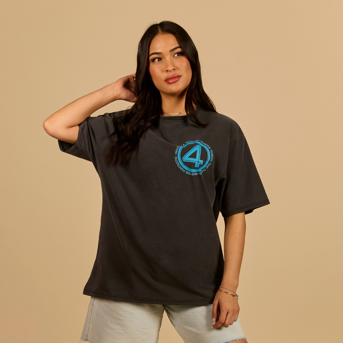 Woman wearing a black t-shirt with a blue logo on a beige background