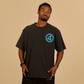 Man wearing a black t-shirt with a blue logo on a beige background