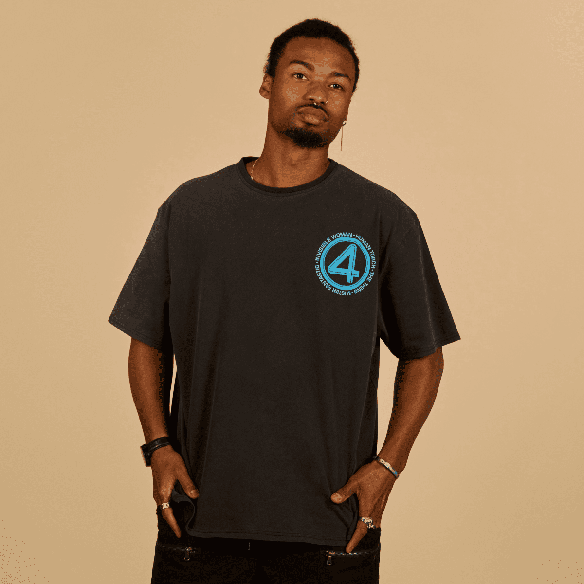 Man wearing a black t-shirt with a blue logo on a beige background
