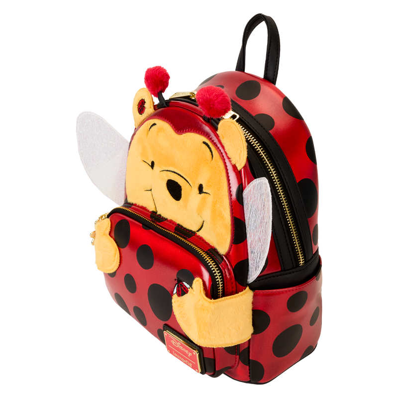 A whimsical Loungefly Disney Winnie the Pooh backpack showcasing Pooh Bear in a ladybug cosplay, with vibrant colors and fun 3D elements.