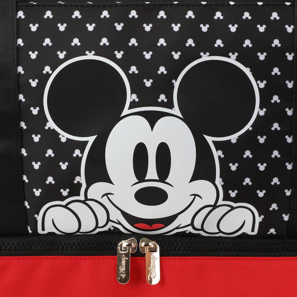 Black bag with white polka dots and a cartoon character peeking out, featuring a red zipper.