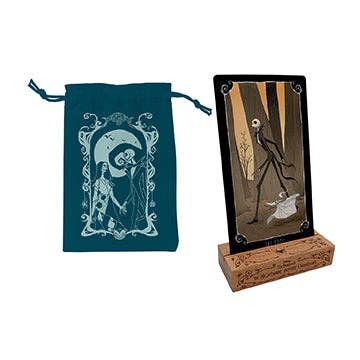 Card with a skeleton design on a stand next to a blue drawstring bag with a similar design.
