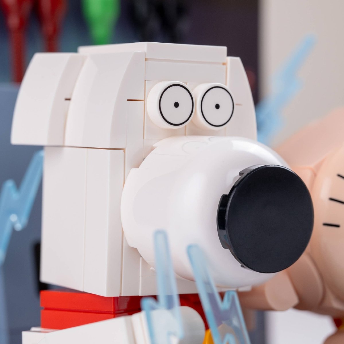 Close-up of a toy camera with a white body, black lens, and red base.
