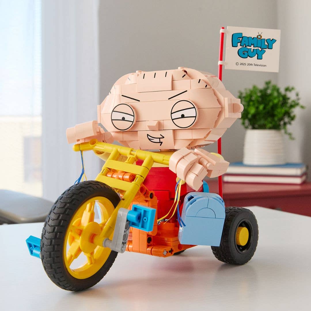 Toy figure of a character from 'Family Guy' riding a bike with a 'Family Guy' sign in the background.
