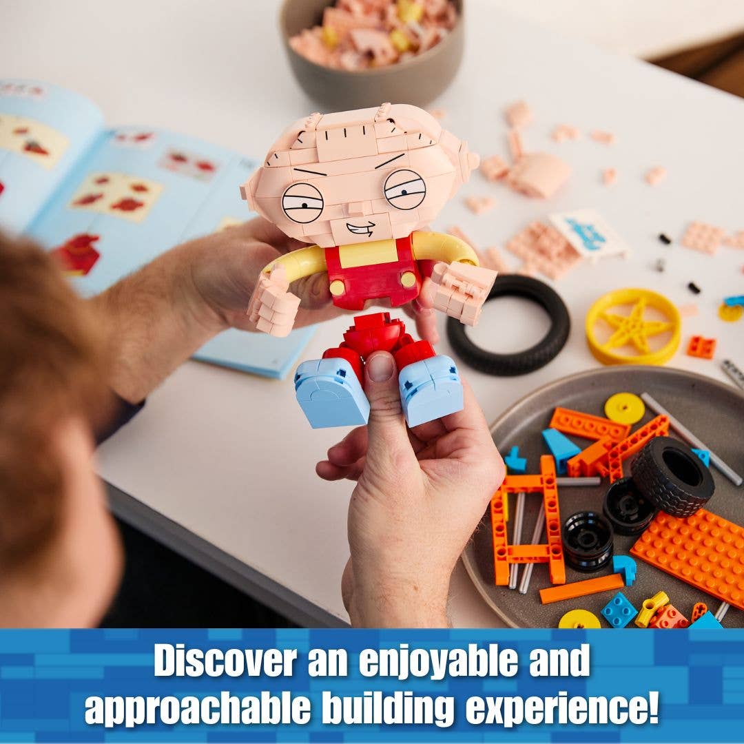 Person holding a small toy figure with building blocks and components on a table.