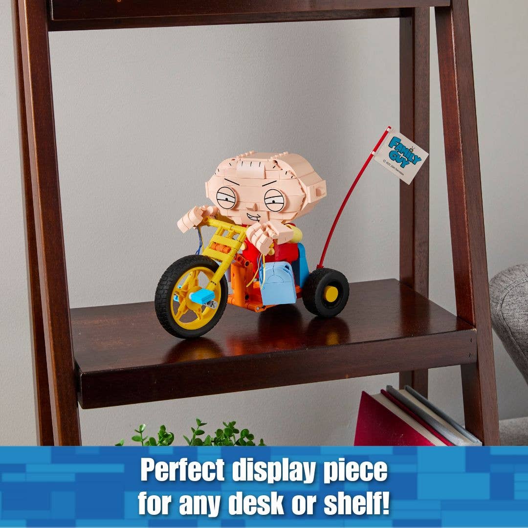 Toy figure of a character on a tricycle on a wooden shelf with a tag, text 'Perfect display piece for any desk or shelf' at the bottom.