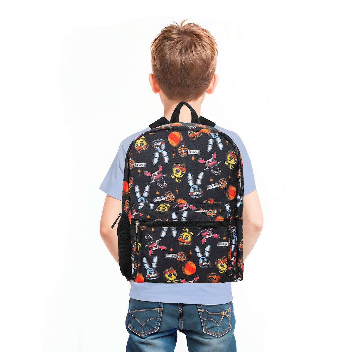 Child wearing a colorful backpack with cartoon characters on a white background