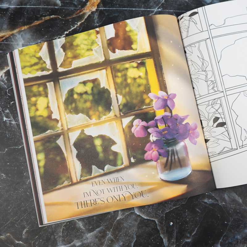 Open book with a window view and vase of flowers on a marble surface