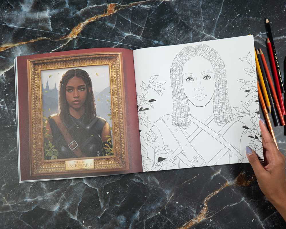 Coloring book open on a marble surface with a hand holding pencils