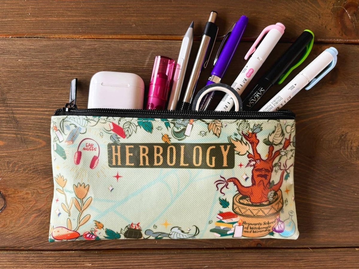 Pencil case with 'Herbology' design on a wooden surface