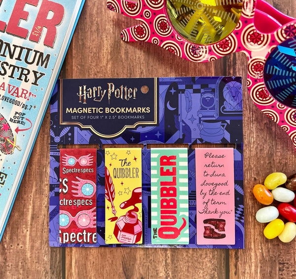 Set of Harry Potter magnetic bookmarks on a wooden surface with jelly beans.