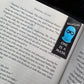 Book with a bookmark featuring a blue mask and text 'One is a Mask' on an open book.