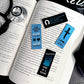 Open book with bookmarks featuring text and symbols on a dark surface