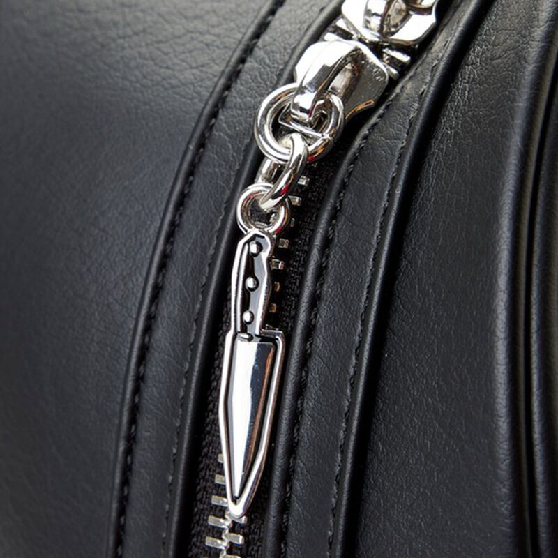 Close-up of a black leather bag with a silver knife-shaped zipper pull.