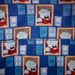 A close-up of patterned fabric featuring a repeating design of a cartoon character in a red outfit framed by blue door motifs on a dark blue background.