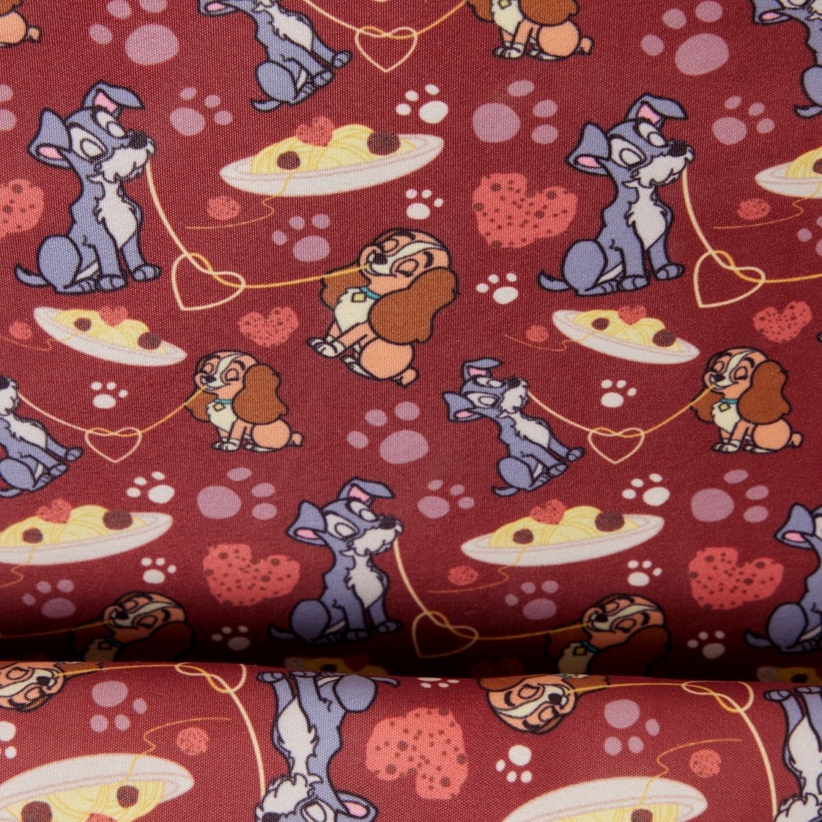 A close-up of patterned fabric featuring cartoon dogs, hearts, and pizza slices on a dark red background.