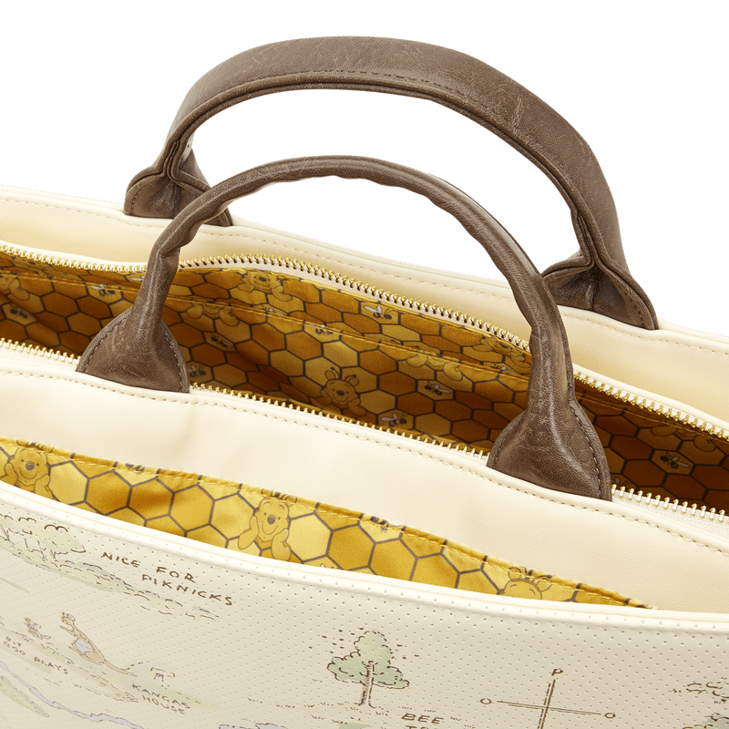 Close-up of a beige bag with brown handles and a detailed interior pattern.