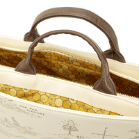 Close-up of a beige bag with brown handles and a detailed interior pattern.