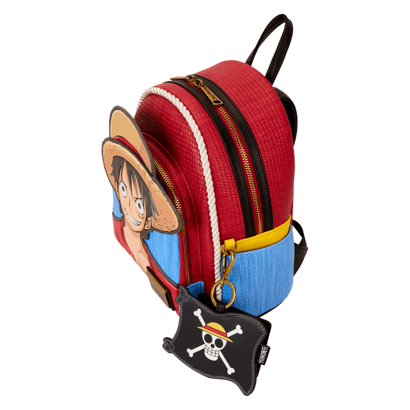 Red and blue backpack with cartoon character and keychain on a white background