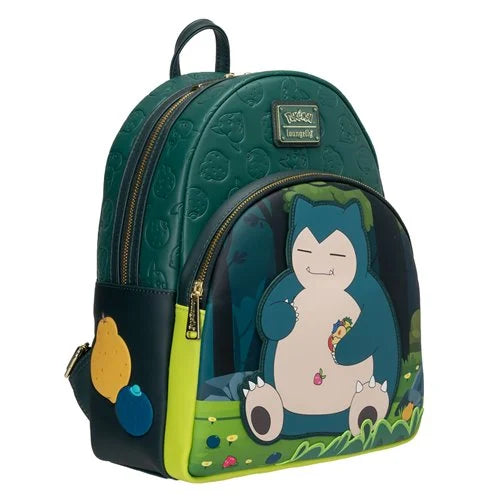 A Loungefly Snorlax backpack featuring a dark green textured body, a large front graphic of Snorlax in a forest, and a side pocket with decorative berry charms, shown on a plain white background.