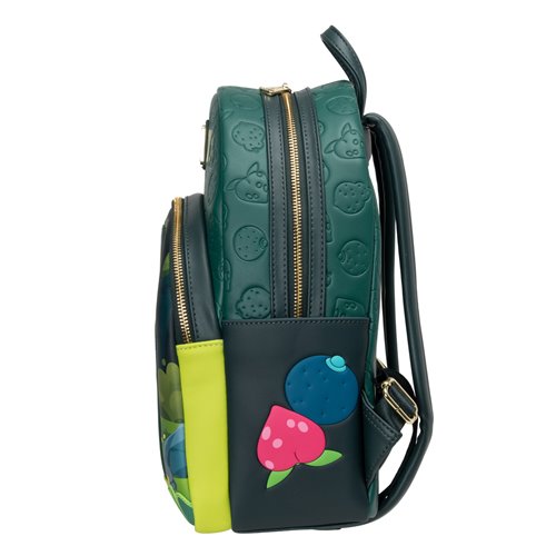 A dark green and black backpack with gold zippers, featuring an embossed fruit pattern on the top section and applique patches of a pink strawberry and a blue blueberry on the front pocket.