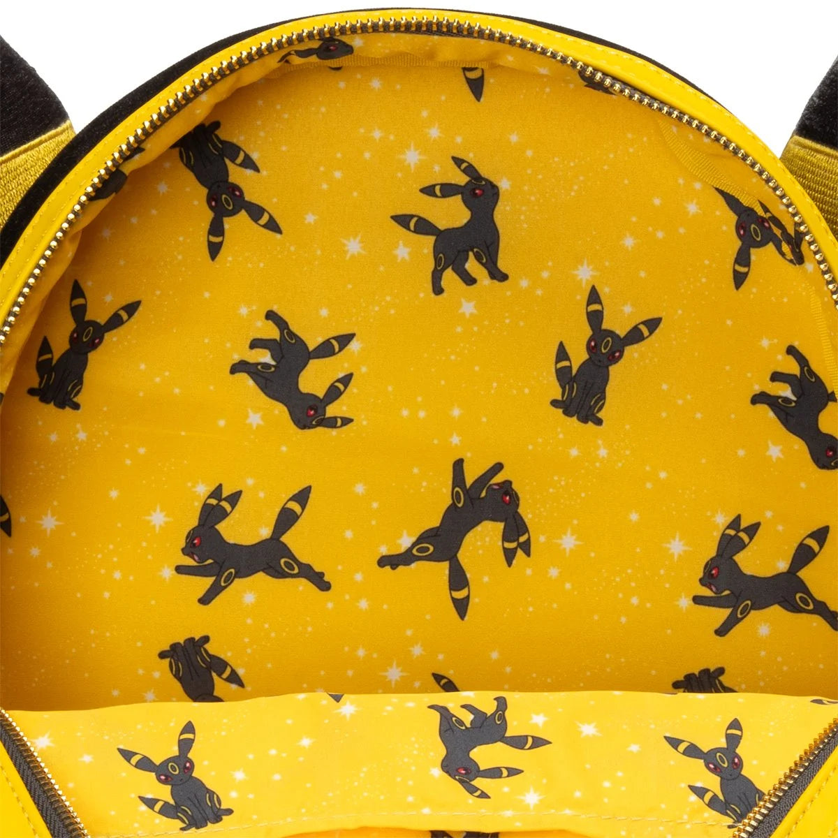 Close-up of a yellow backpack interior featuring a repeating pattern of black silhouette characters on a starry yellow background, with a matching yellow zipper trim.