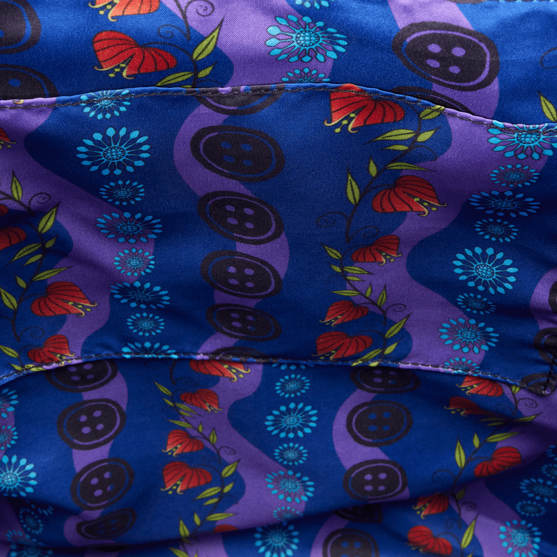 Close-up of a colorful fabric with floral and button patterns on a blue background.