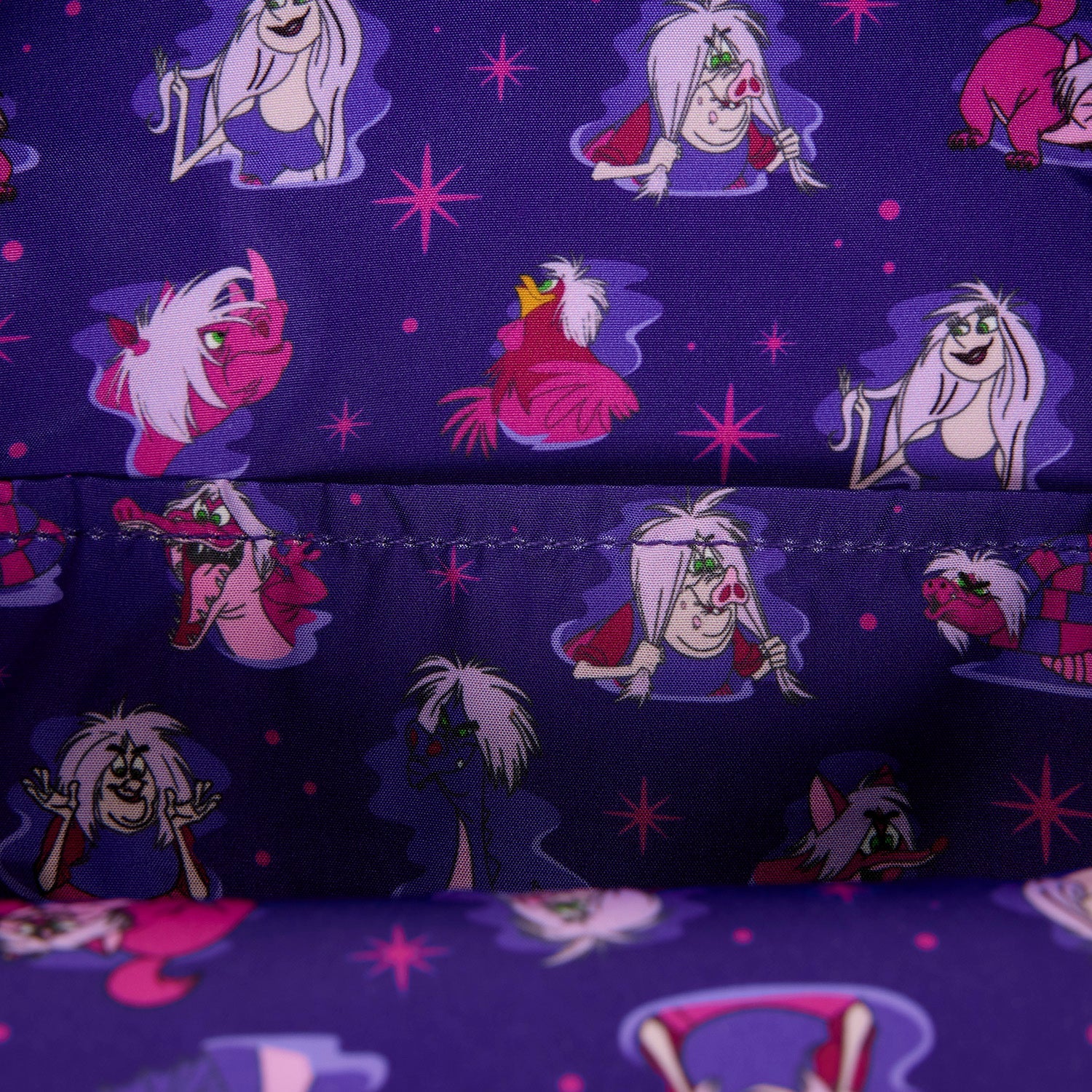 A close-up of a purple fabric printed with cartoon characters in pink, white, and red, including a central character with a green bow and a pink bird-like figure, with a stitched seam visible across the middle.