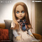 Doll with long blonde hair and blue eyes, wearing a striped shirt and bow tie, sitting on a couch.