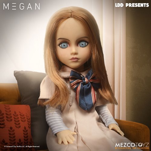 Doll with long blonde hair and blue eyes, wearing a striped shirt and bow tie, sitting on a couch.
