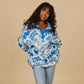 Person wearing a blue and white patterned jacket on a beige background