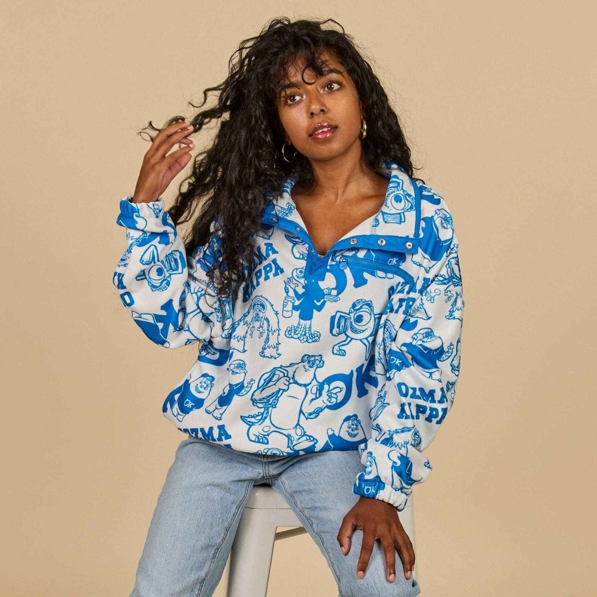 Woman wearing a blue and white patterned shirt against a beige background