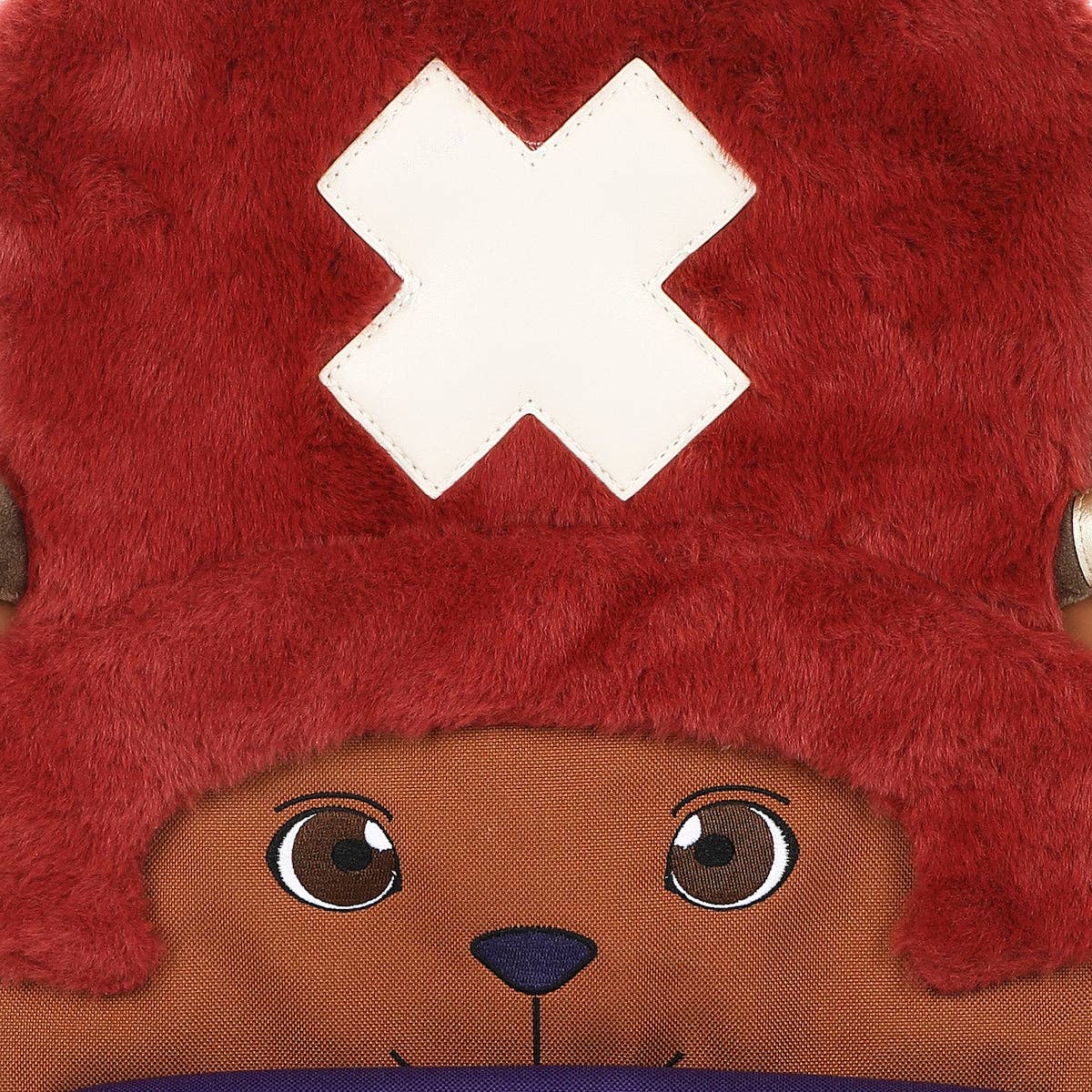 Close-up of a plush toy with a red hat and brown face