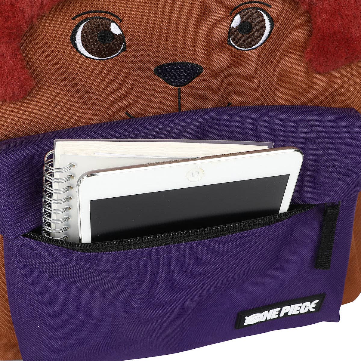 Purple backpack with a bear face design, open to reveal notebooks and a pen.