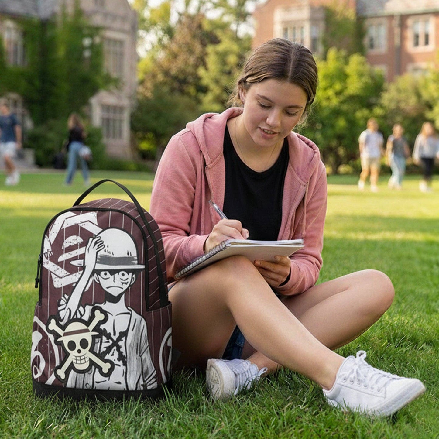 Person sitting on grass with a backpack and notebook, with a building and trees in the background