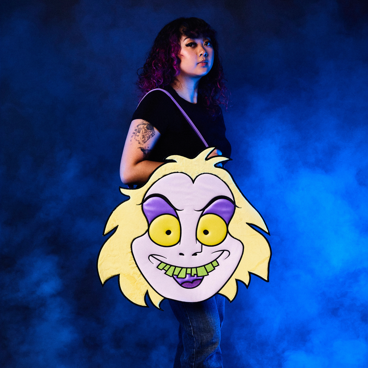 Person holding a large, Oversized Beetlejuice Tote Bag with a blue smoky background