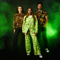 Three people wearing patterned outfits with a green smoke effect