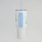 Clear tumbler with blue handle and straw on a light gray background
