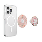 A clear protective phone case with a MagSafe ring, shown alongside two interchangeable back accessories: a round pink floral pattern insert and a round pop socket featuring a cartoon cat illustration with a pearl border.