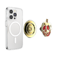 A clear protective phone case with a MagSafe ring, shown alongside a gold circular magnetic mount and a gold-and-red skull-shaped accessory on a plain white background.