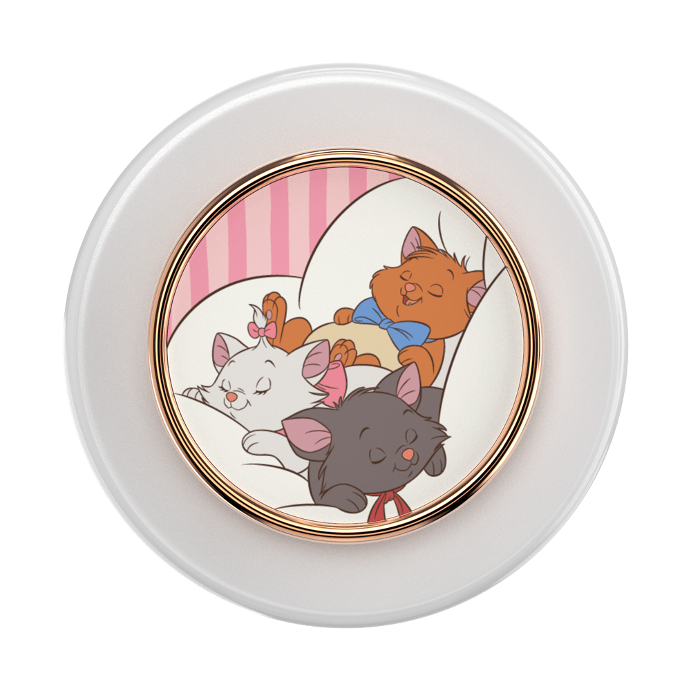 A round white cosmetic compact or container with a gold-toned inner rim and a colorful illustration of three sleeping cats on the front. The cats are in a pink-striped room, with one orange cat wearing a blue bow tie and one dark gray cat wearing a red bow tie.