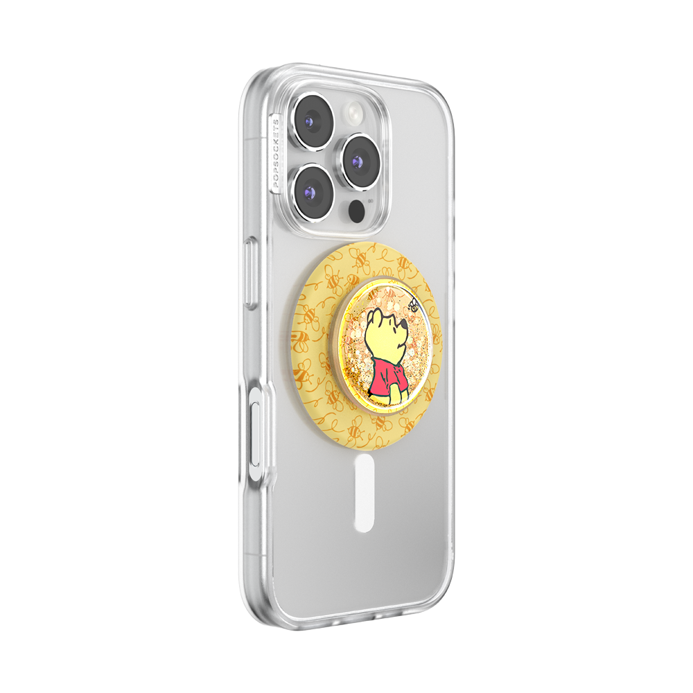A clear protective phone case on a silver smartphone, featuring a circular yellow and orange patterned pop socket with a cartoon character on the back.